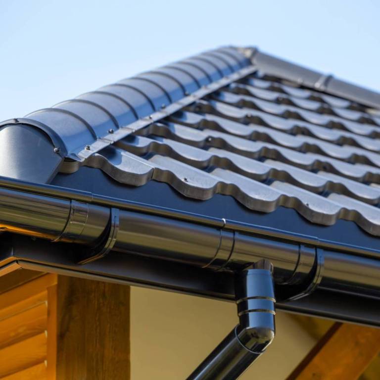 Corner of the new modern house with roof, gutter and wooden shut Corner of the new modern house with roof, gutter and wooden shutter under blue sky